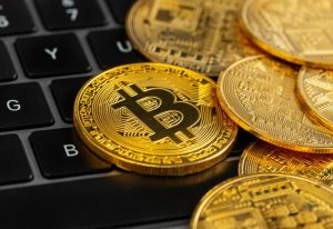 Golden Bitcoins above computer keyboard