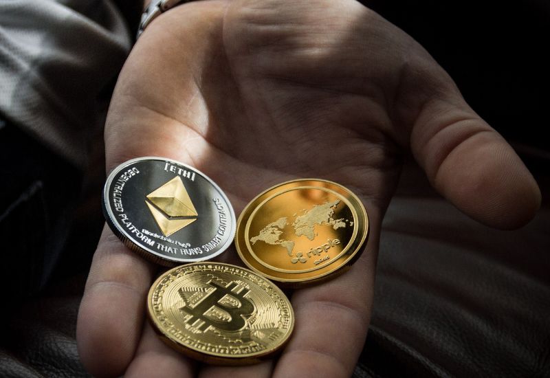 A Hand with 3 Crypto Coins