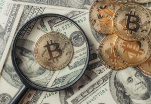 Bitcoins under a loop and above dollar bills