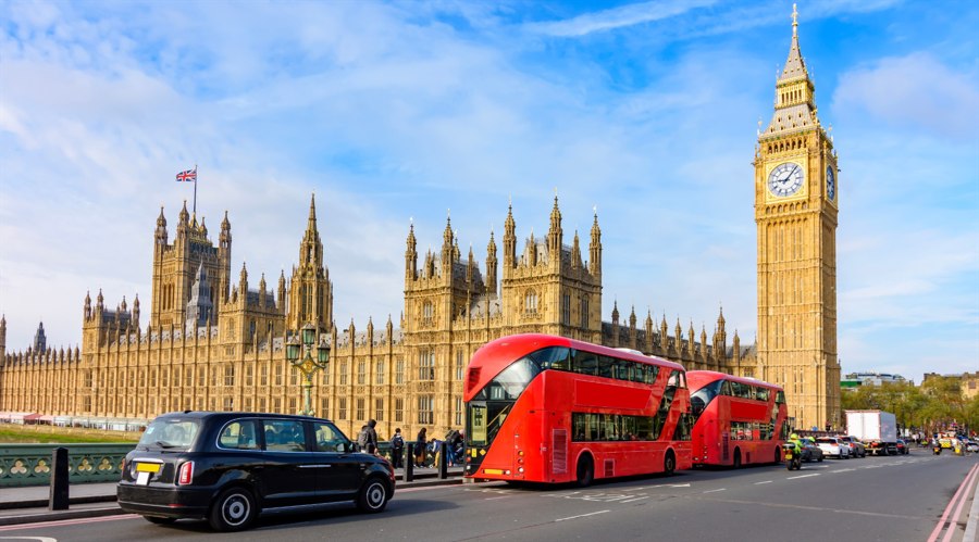 Double-decker buses and black cab with Big Ben and Houses of Parliament in London