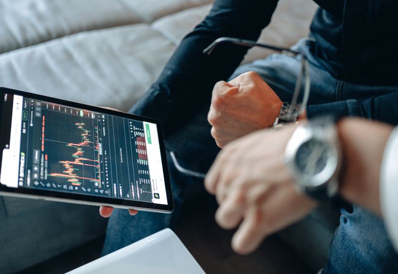 Investors in front of a Tablet with Crypto Trading Graphic
